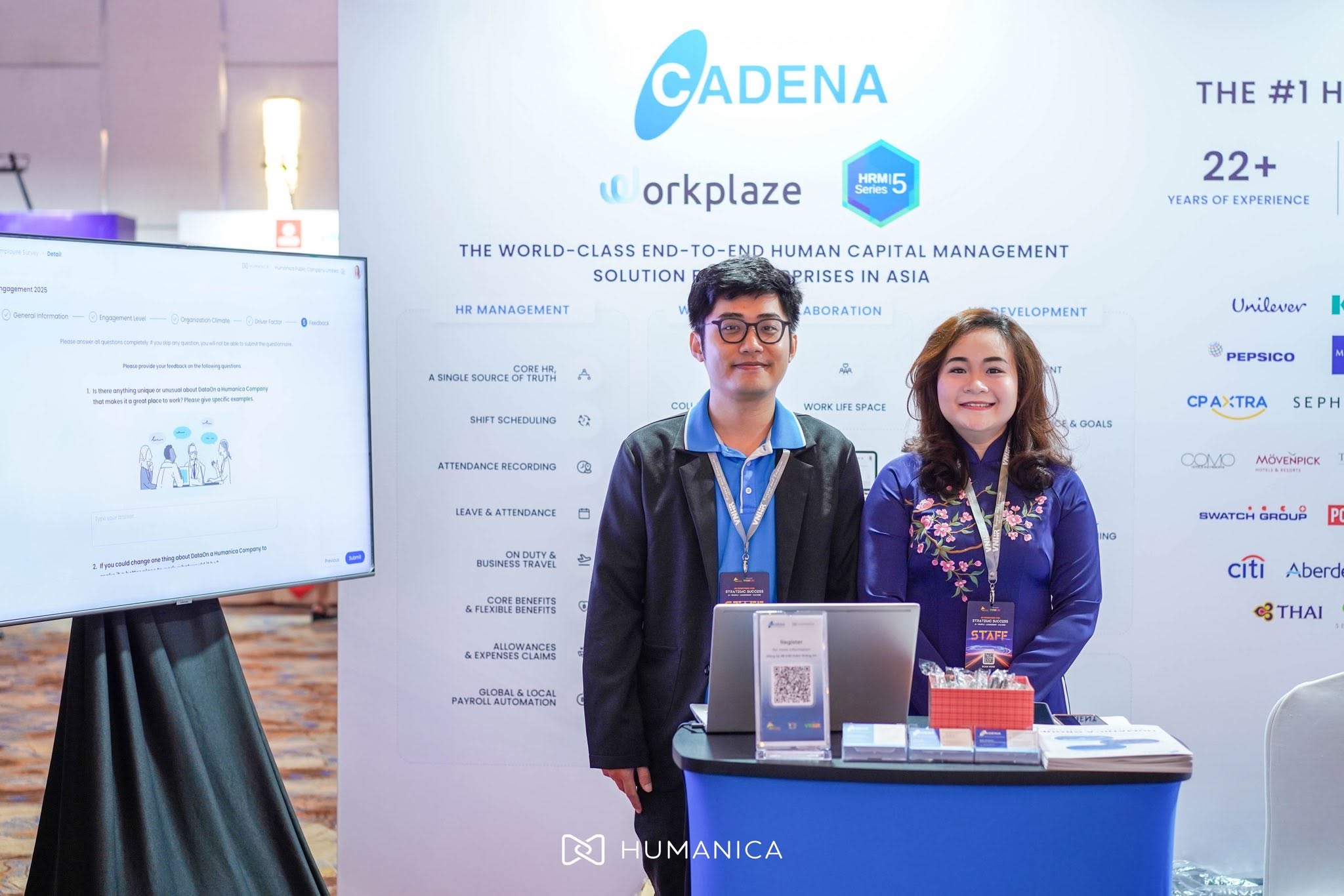 Cadena and Humanica team members standing behind the booth counter
